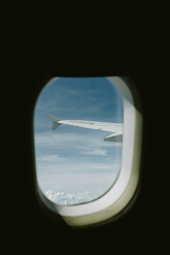 Vue du ciel et d’une aile d’avion à travers un hublot — illustration